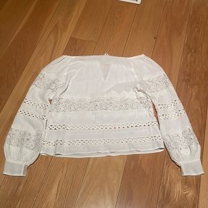 Gorgeous white blouse with lace type patterns and draw string neck
